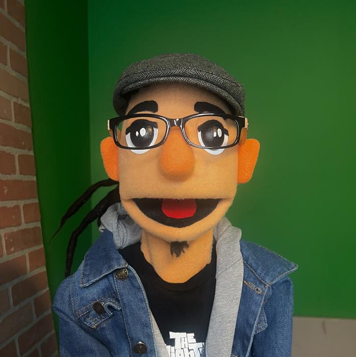 Puppet character portrait in a denim jacket, green backdrop