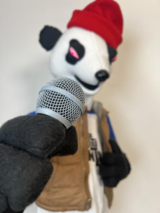 Panda puppet character with microphone in the studio