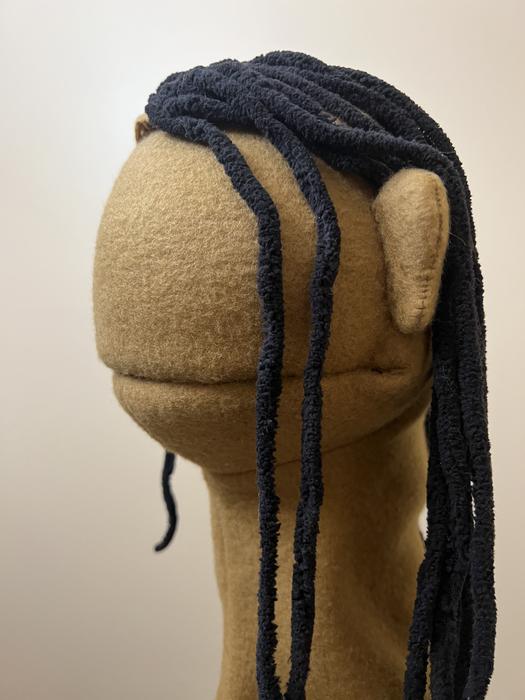 Close-up of a puppet head with yarn dreadlocks