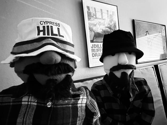 Two puppet characters in bucket hats, black and white photo