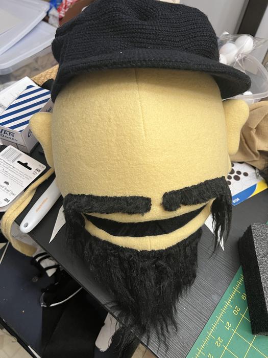 Puppet head in progress with beard being attached, back view